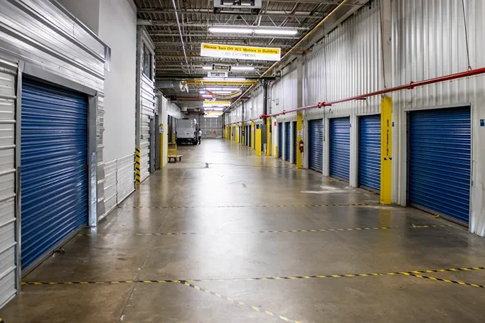 Indoor drive-in storage loading area with wide lanes and secure unit access